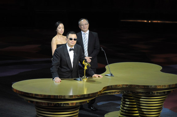 Wong Kar Wai receives the Best Director Award at the 8th Asian Film Awards from Ambassador Jeon Do Yeon and Johnnie To